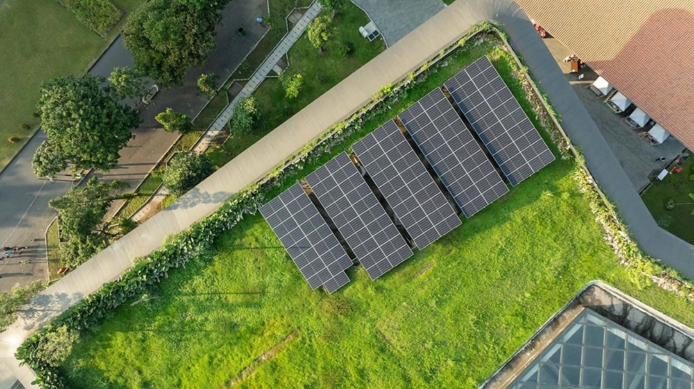 Extenzivní zelená střecha se solárními panely na moderní budově při pohledu shora